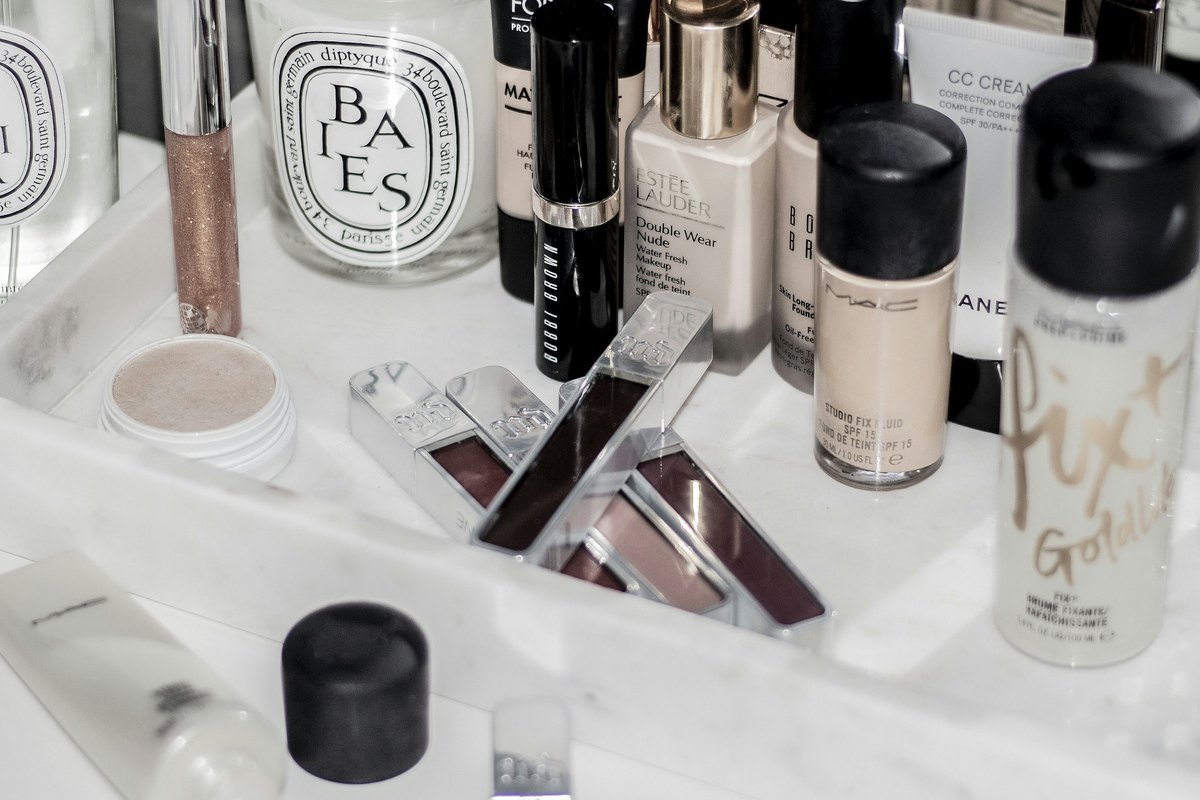 A marble vanity tray layered with luxury beauty products