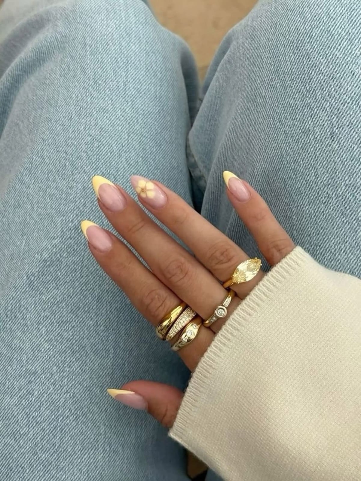 Butter yellow French tip manicure with a small flower accent
