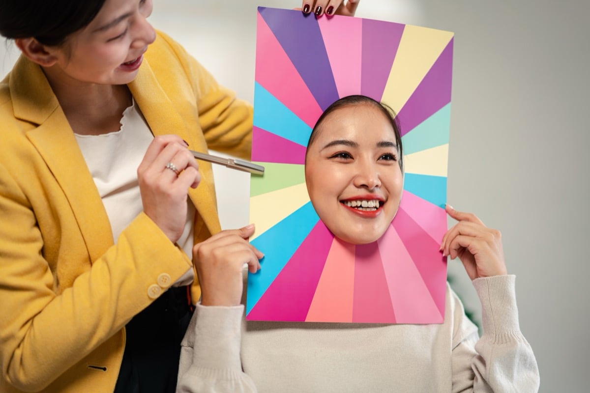 A woman's face framed by a fan of bright colors during a color analysis